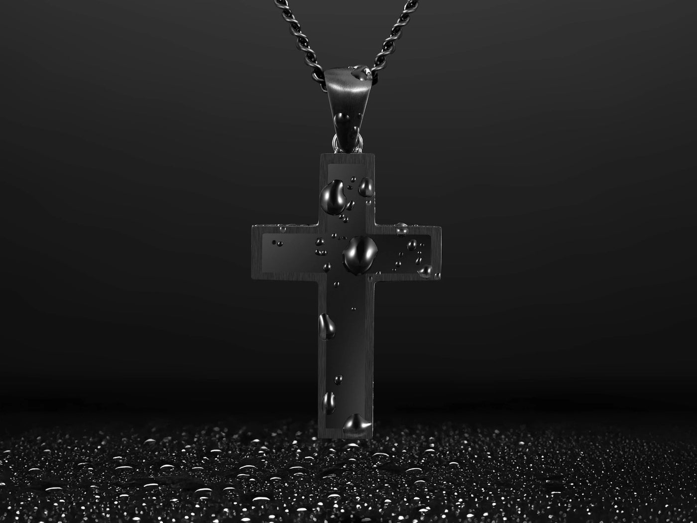 Close-up of a black cross pendant with a black chain, with water droplets on the pendant. 