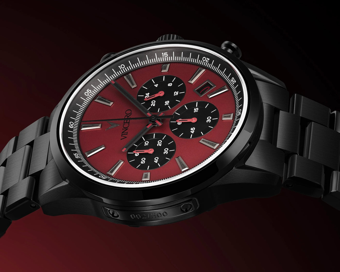 Black wristwatch with a red face on a dark background