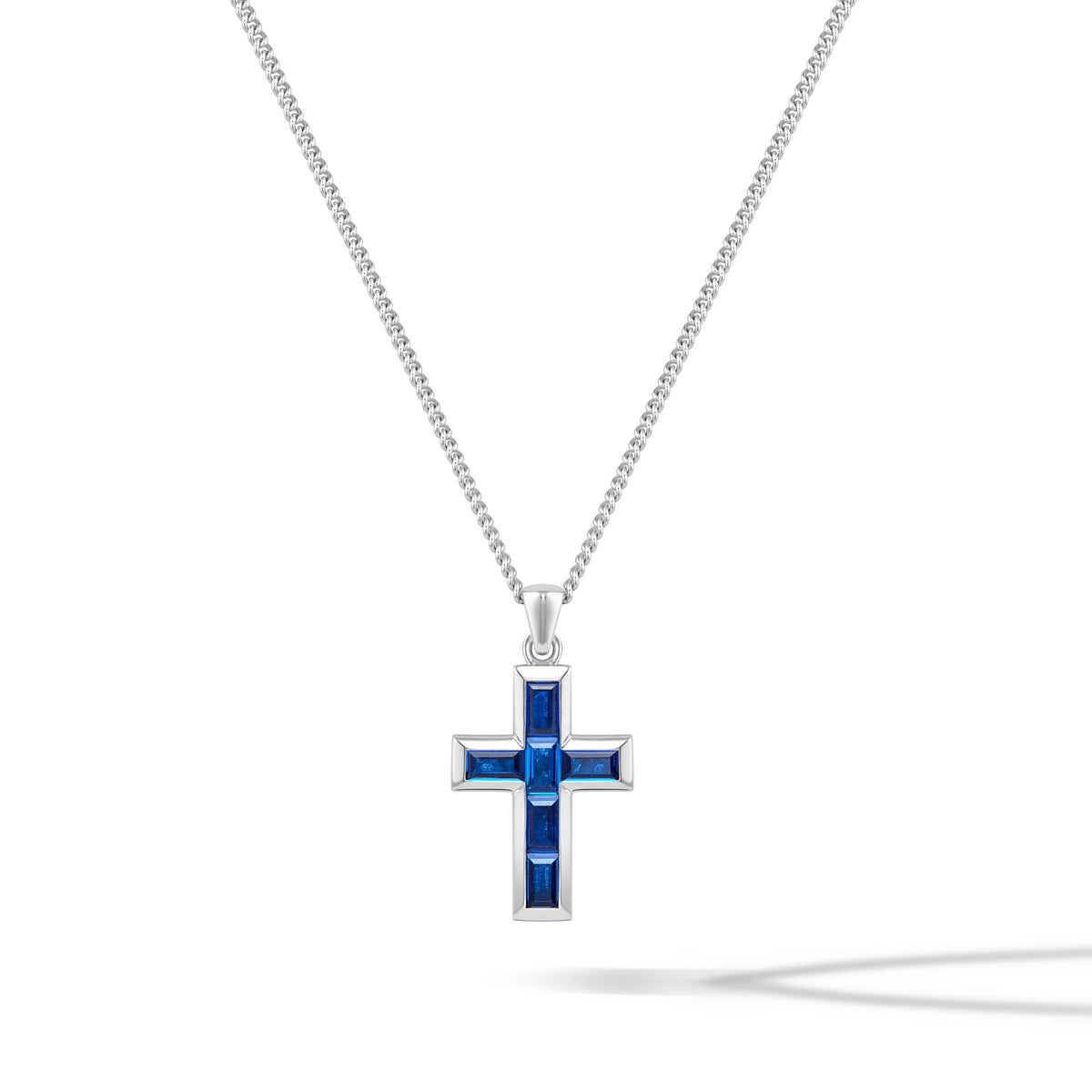 A silver cross pendant necklace with a blue sapphire inset, displayed against a white background.