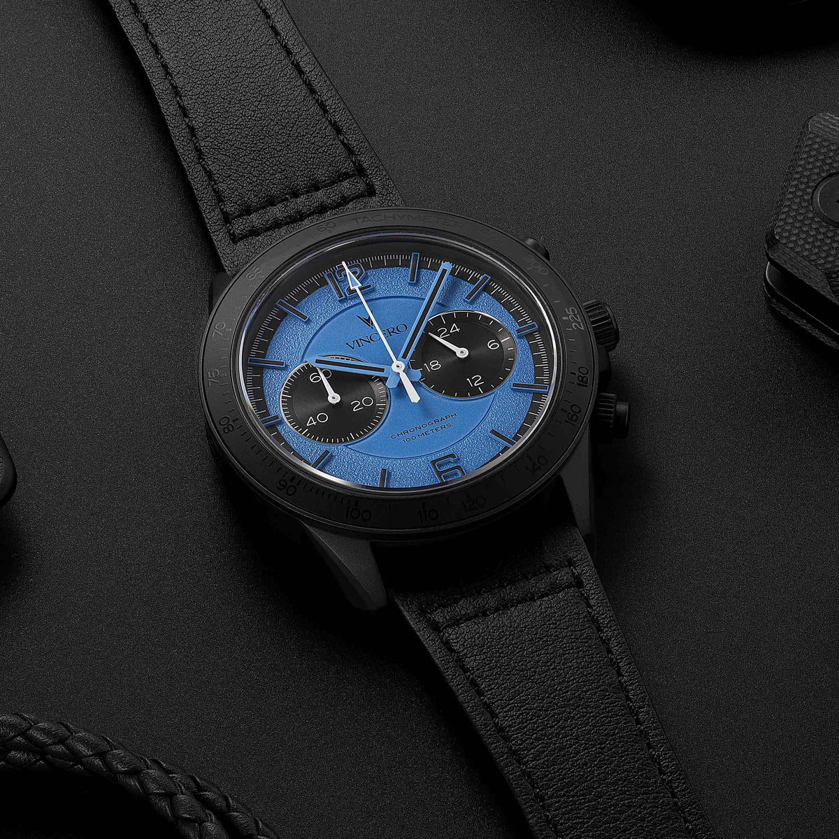 Apex Limited Edition watch, featuring a blue face and matte black band, displayed on a desk with EDC items. 