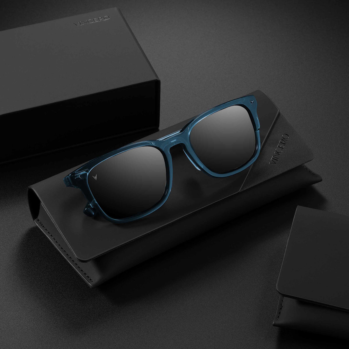Blue sunglasses on a black stand with a dark background