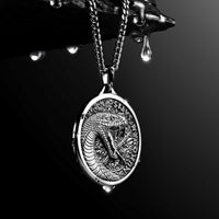 Silver snake pendant necklace on a dark background