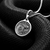 Silver snake pendant necklace on a coiled black snake