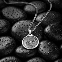 Silver necklace with a pendant on wet stones