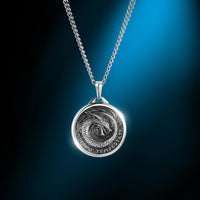Silver necklace with a dragon pendant on a blue gradient background
