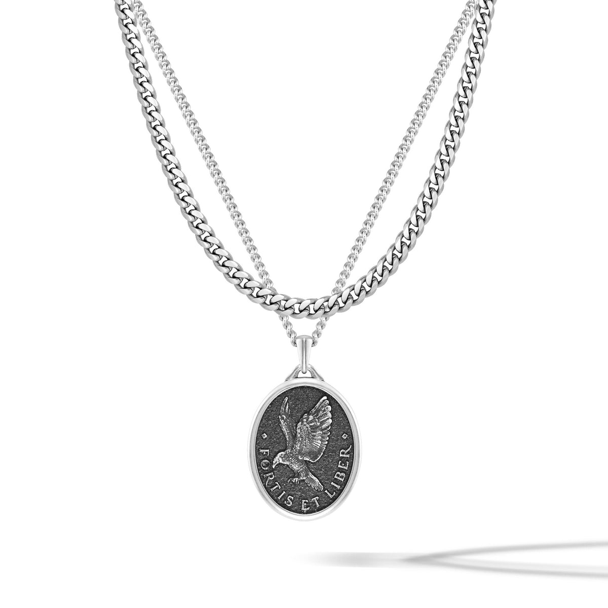 Silver necklace with a pendant featuring an eagle design on a white background