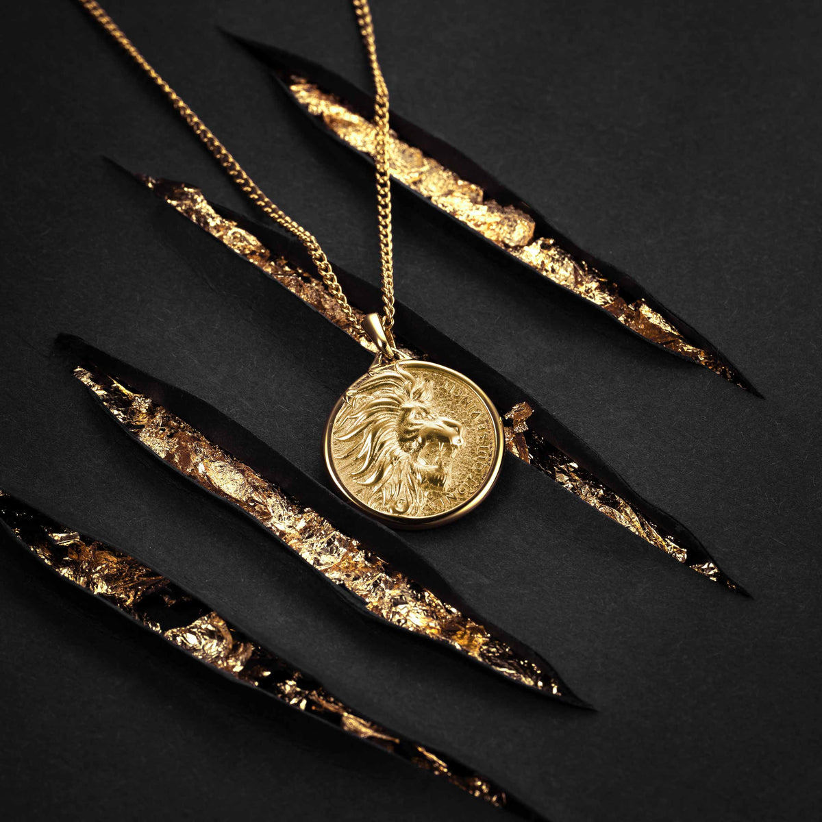 Gold necklace with a lion head pendant on a black background
