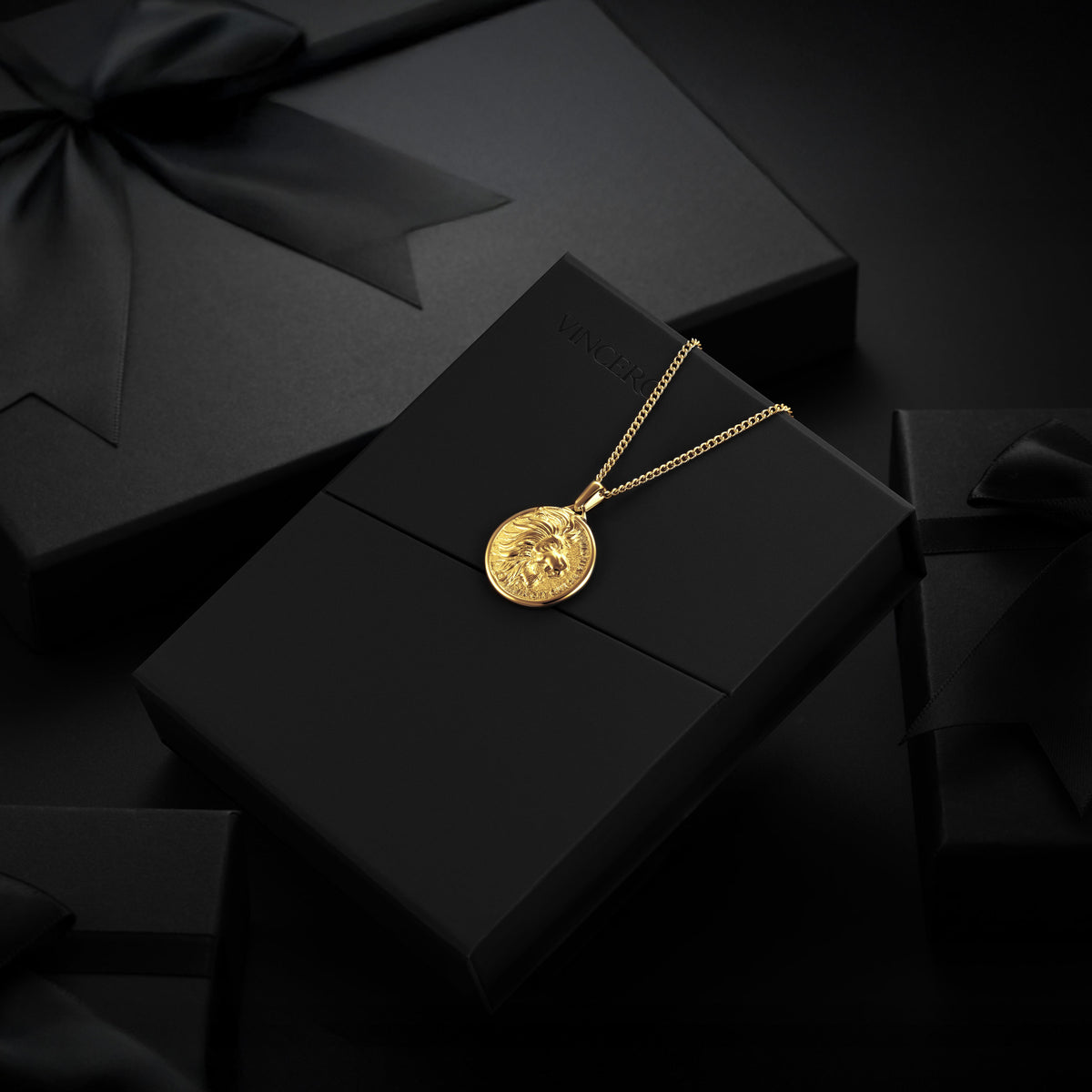 Gold Lion necklace with a pendant on a black box