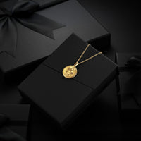 Gold Lion necklace with a pendant on a black box