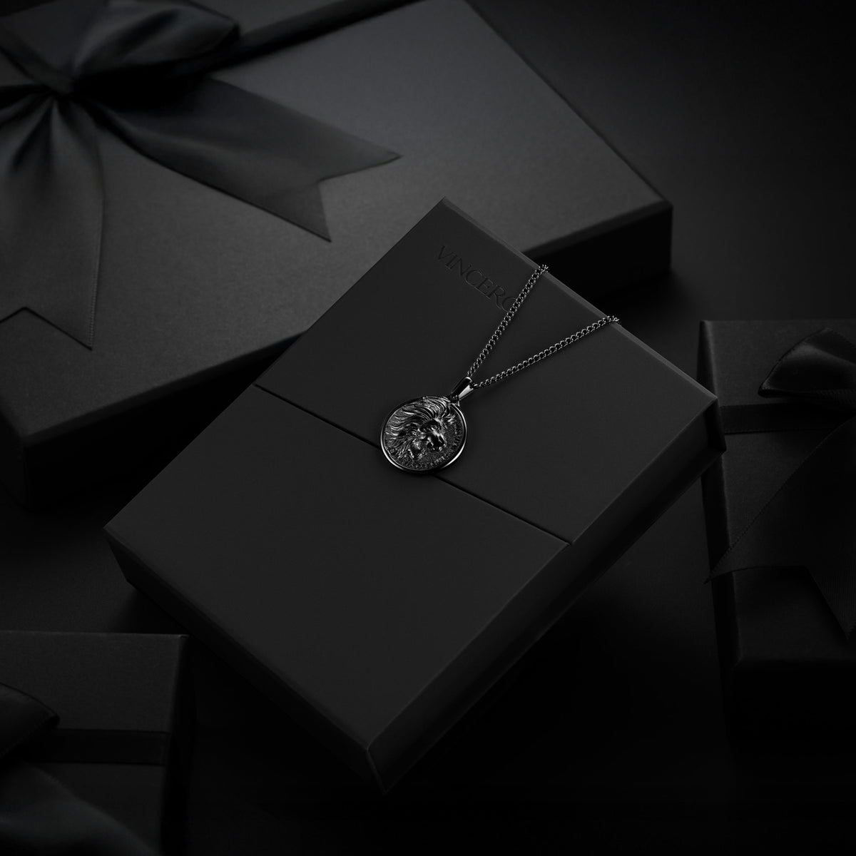 Silver necklace with a pendant on a black box against a dark background