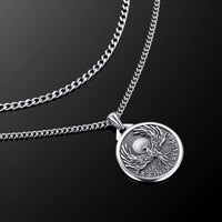 Silver necklace with a detailed pendant on a black background