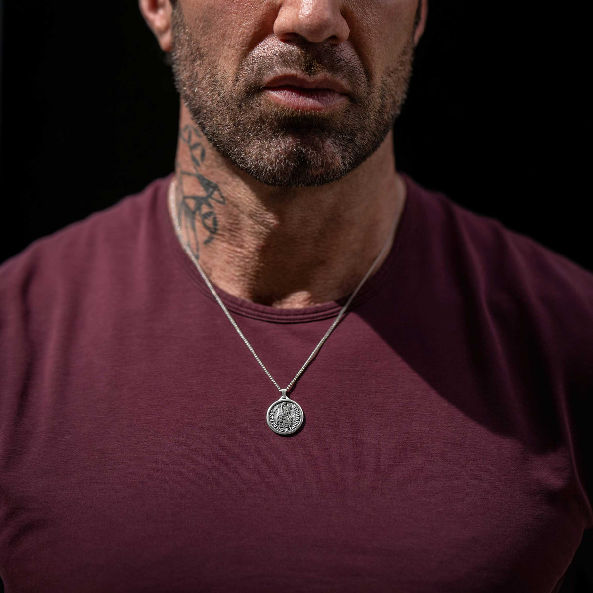 Man wearing silver chain necklace with silver Spartan pendant