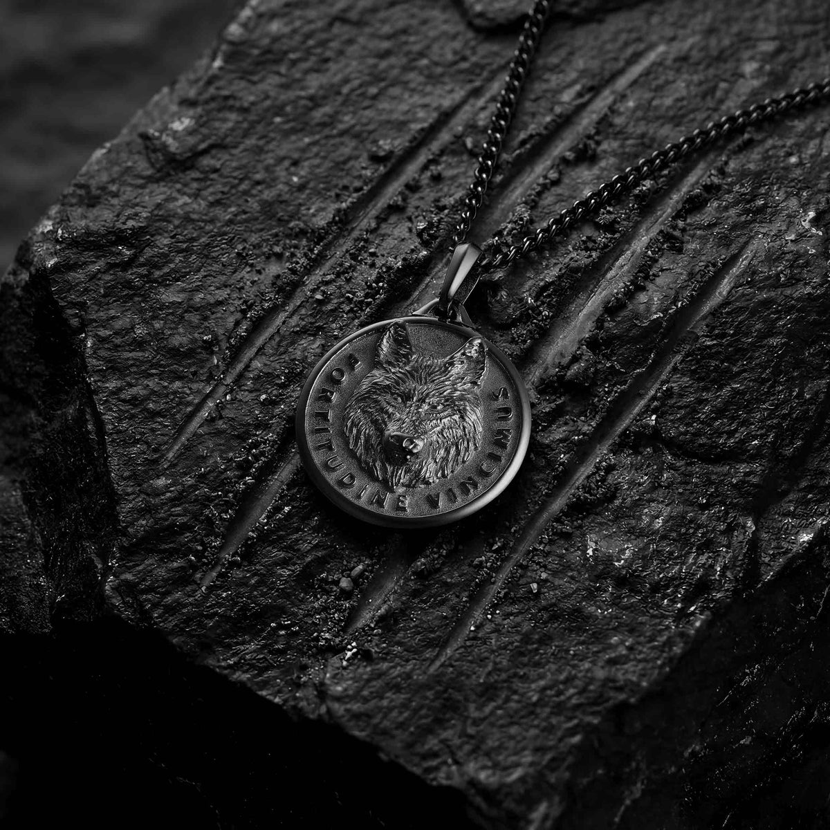 Black wolf pendant for man on black lava rock with scratches 