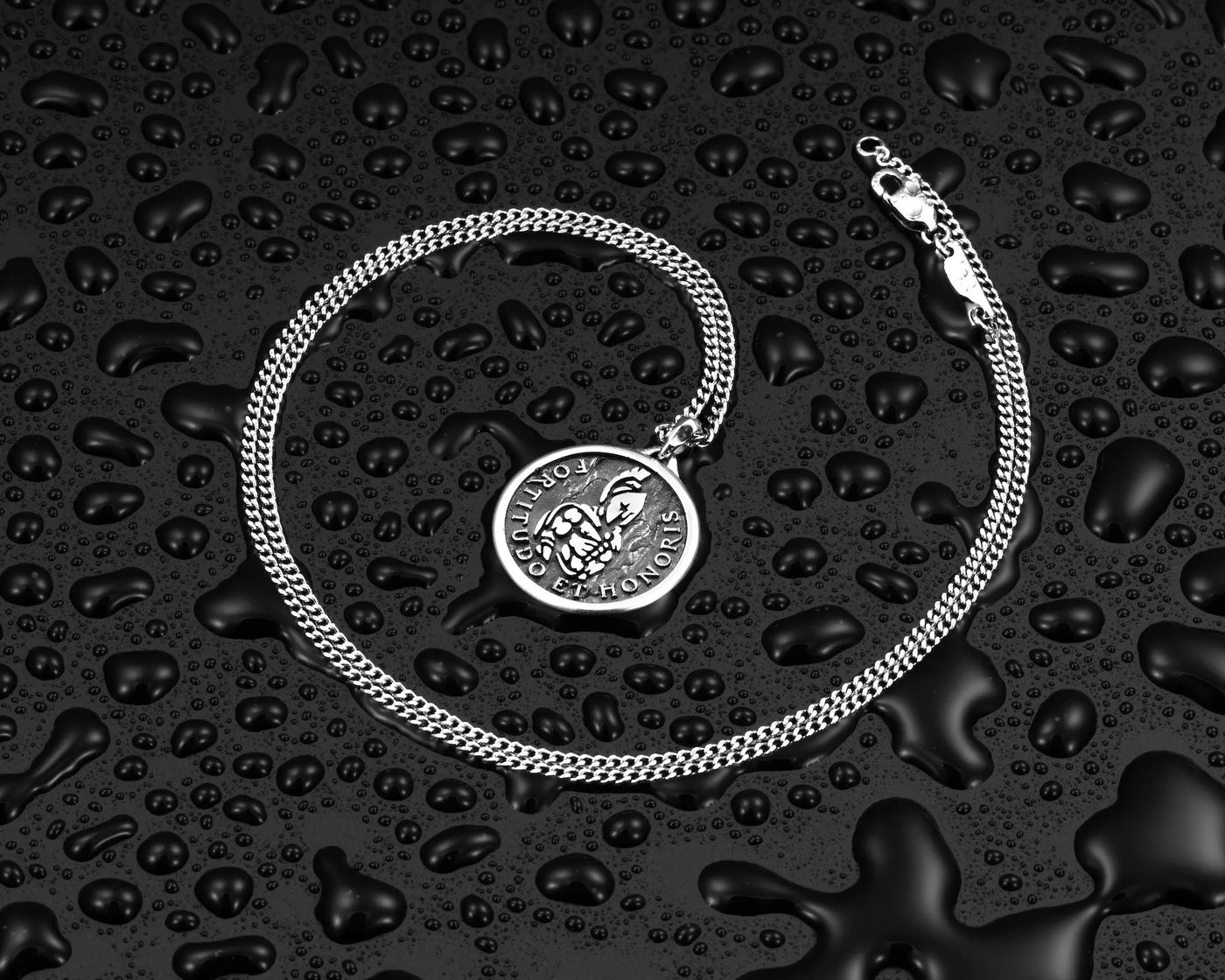 Silver chain necklace with silver Spartan pendant, surrounds by water droplets. 
