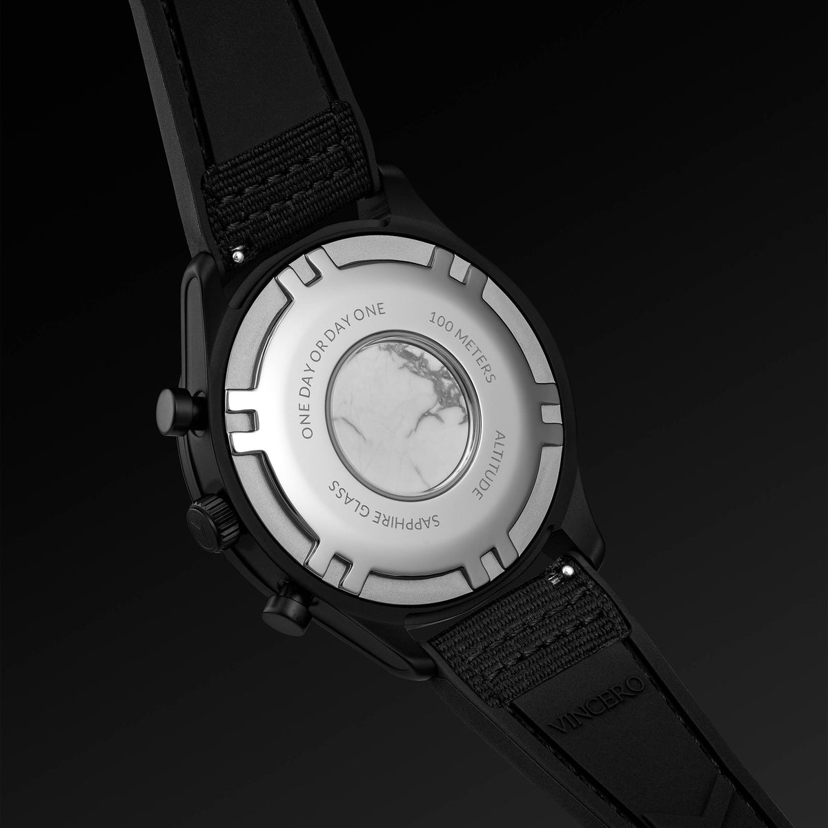 Close-up of a watch with a black strap and silver case on a dark background