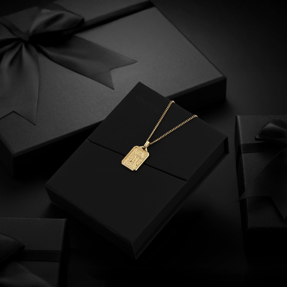 Gold necklace with a pendant on a black box