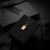 Gold necklace with a pendant on a black box