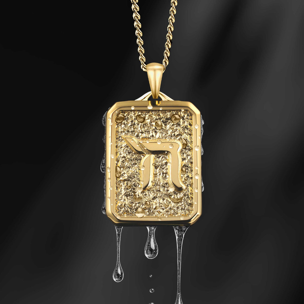 Gold pendant with a Hebrew letter on a dark background