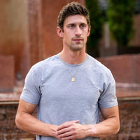 Man wearing a gray t-shirt with a blurred background
