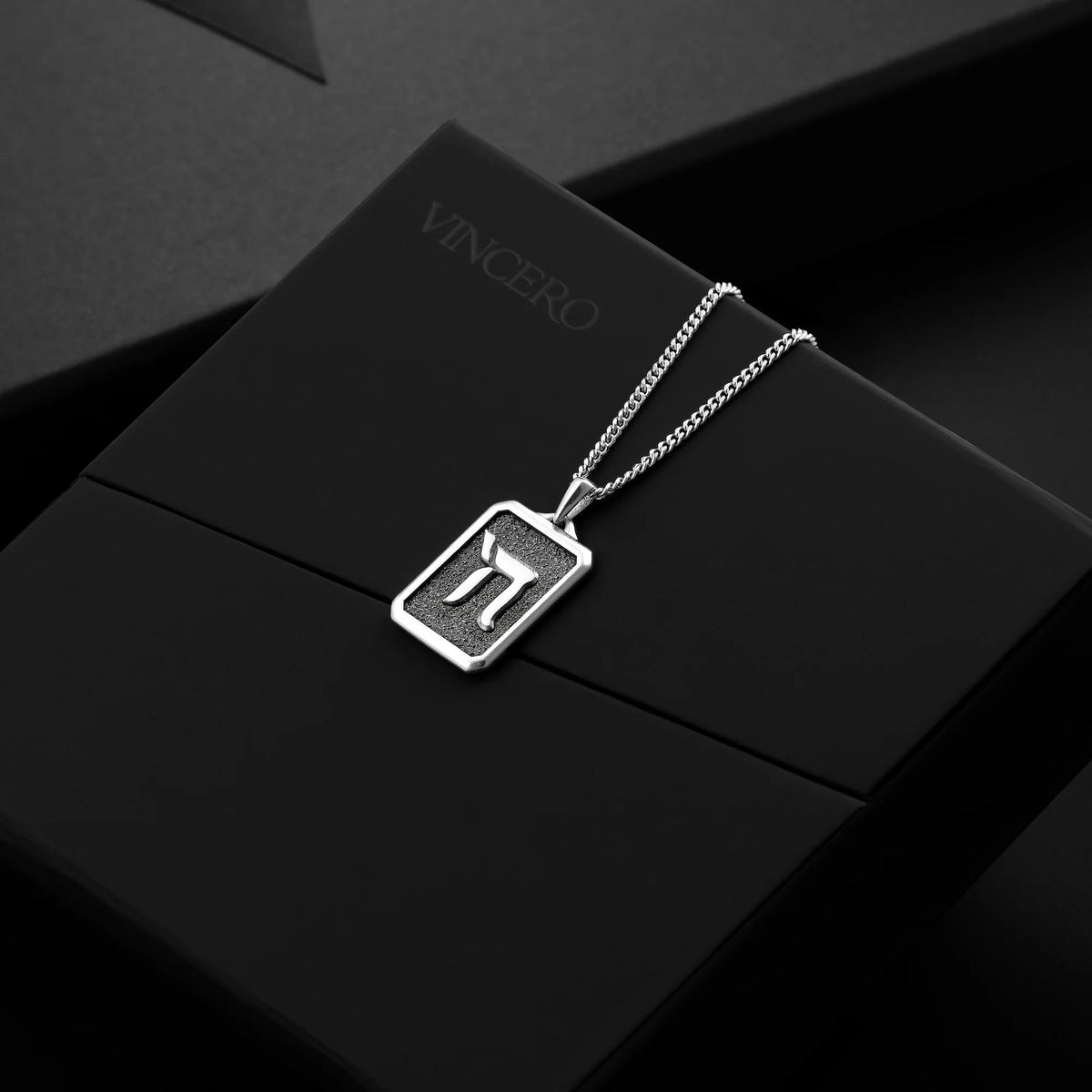Silver necklace with a pendant on a black box labeled 'Vincero'.