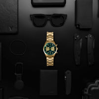Gold watch with green face on a black background