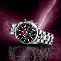 Silver wristwatch with a black face on a reflective purple surface