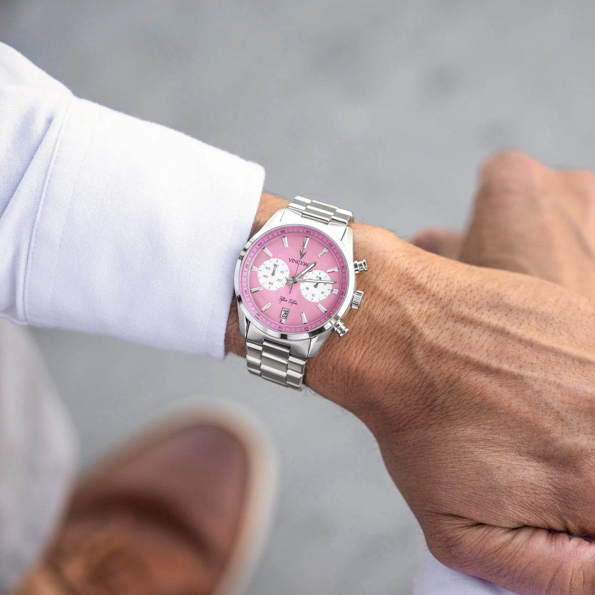 Man wearing Father’s Edition watch, featuring a pink face, stainless steel casing, and steel band.
