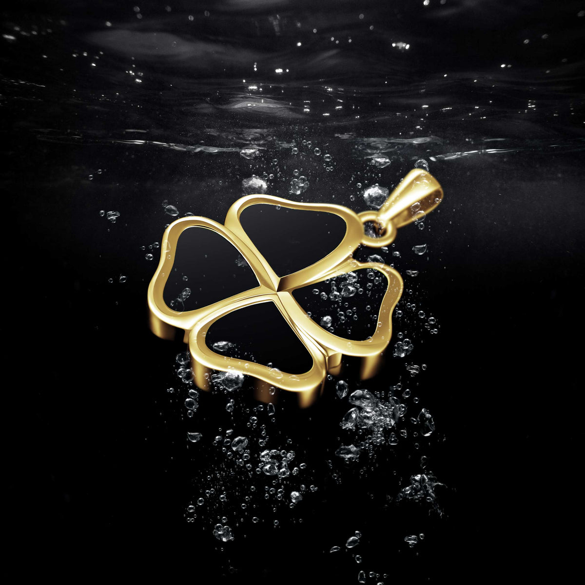 Gold four-leaf clover pendant on a reflective black surface