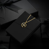 Gold necklace on a black box with a black background