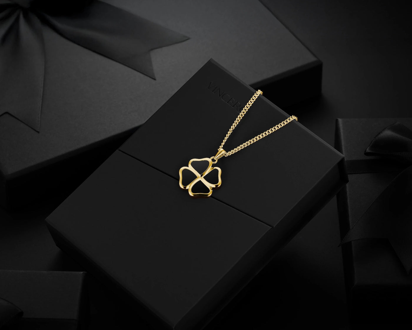 Gold necklace with a geometric pendant on a black surface
