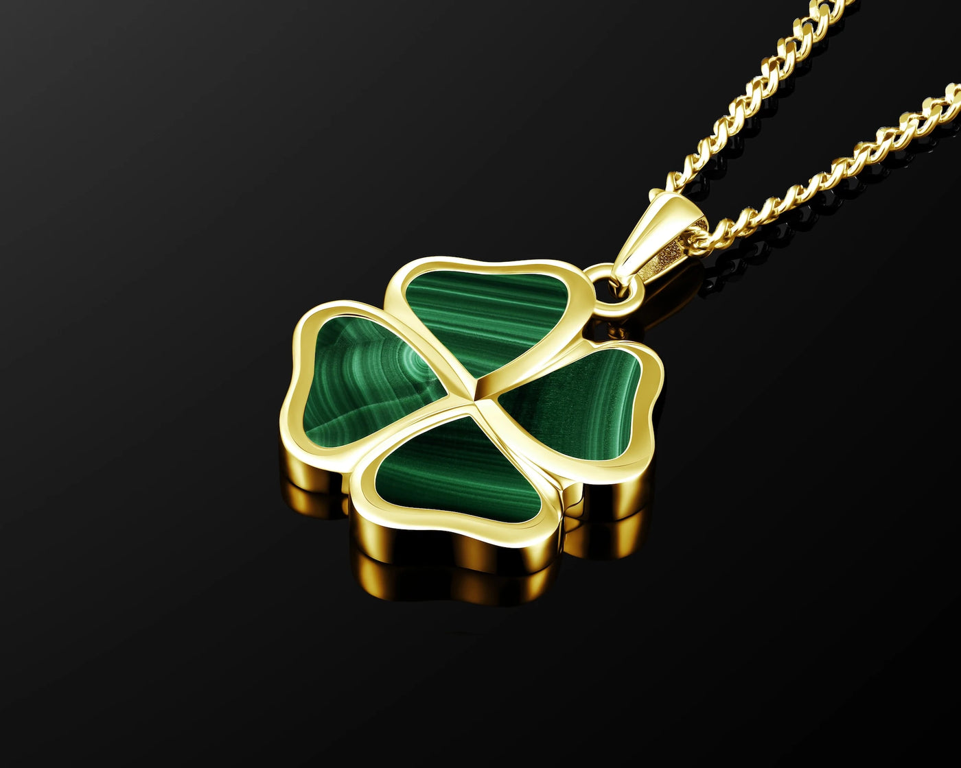 A gold four-leaf clover pendant necklace with green malachite inlay, shown on a black reflective background.
