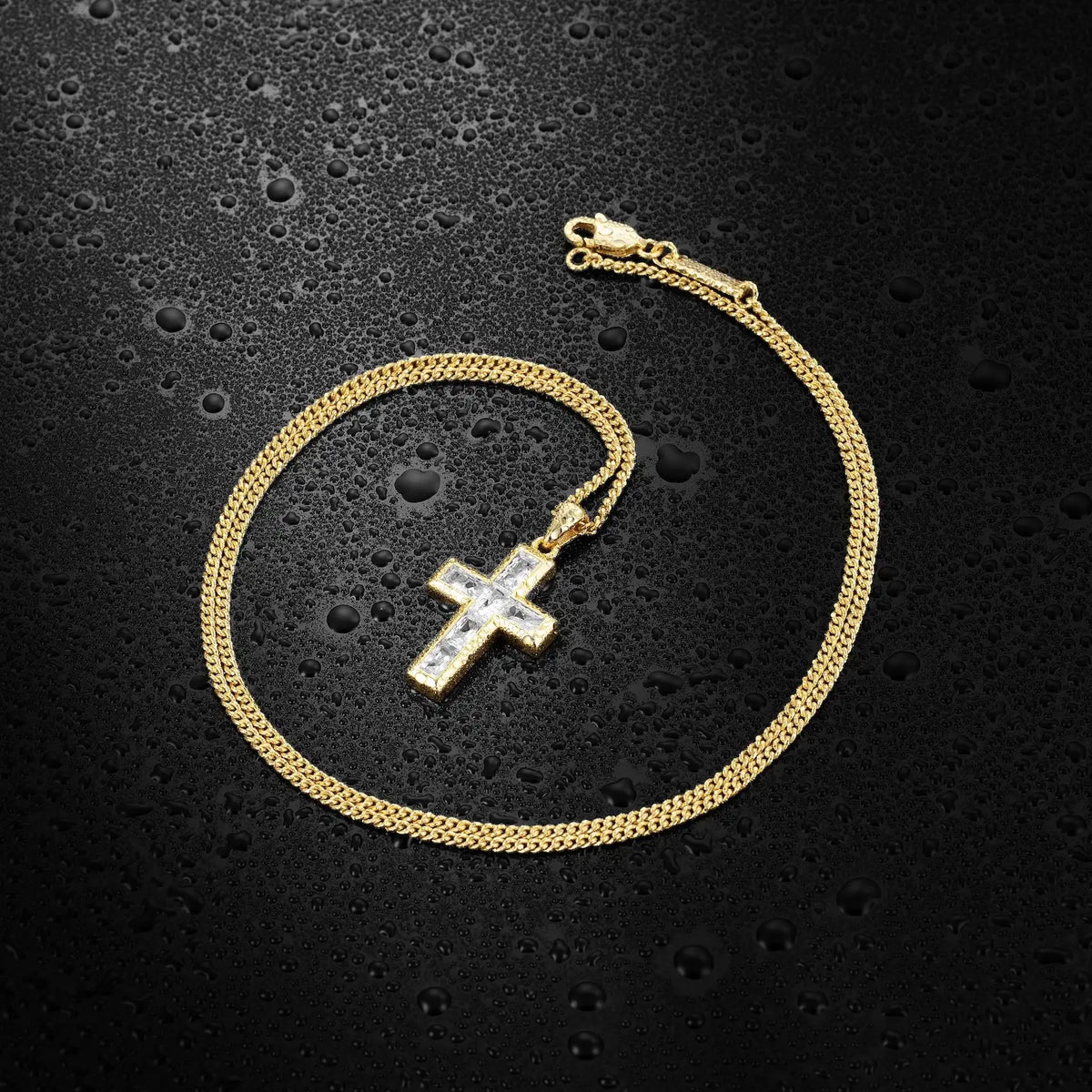Gold chain necklace with a cross pendant on a black textured background