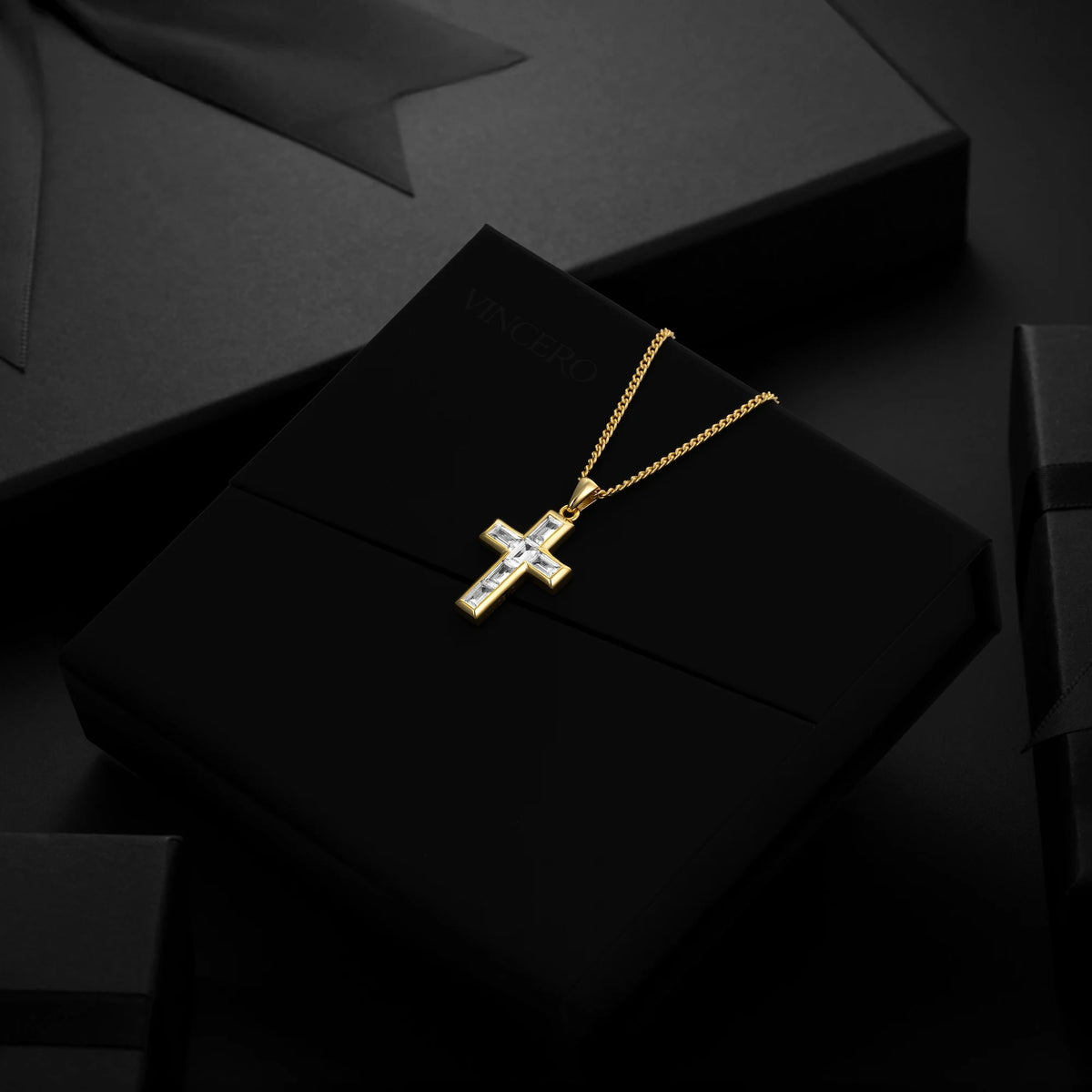 Gold cross necklace on a black surface