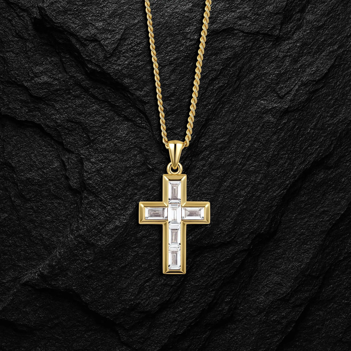 Gold cross pendant necklace on a black stone background