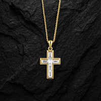 Gold cross pendant necklace on a black stone background
