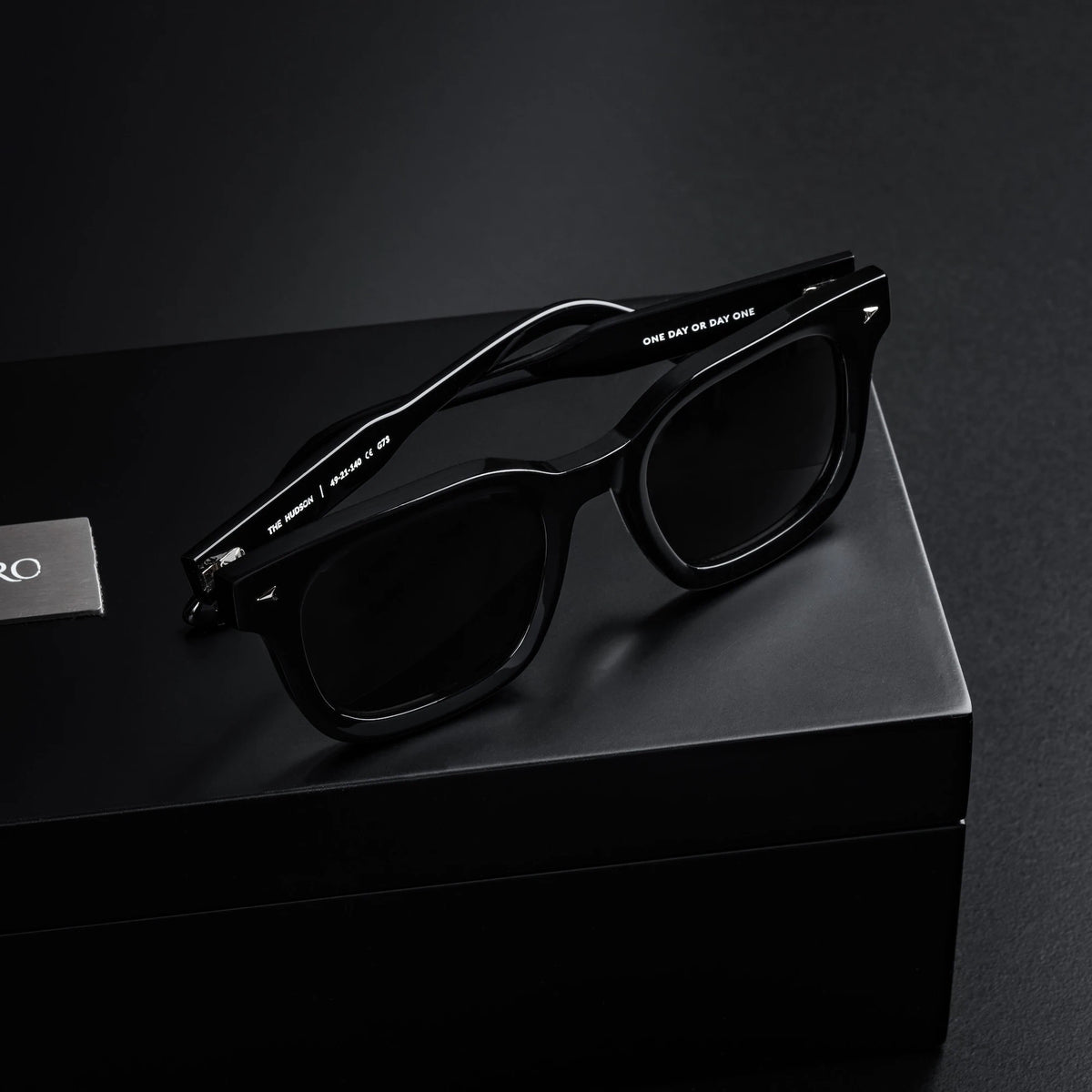 Black sunglasses on a black box with a dark background