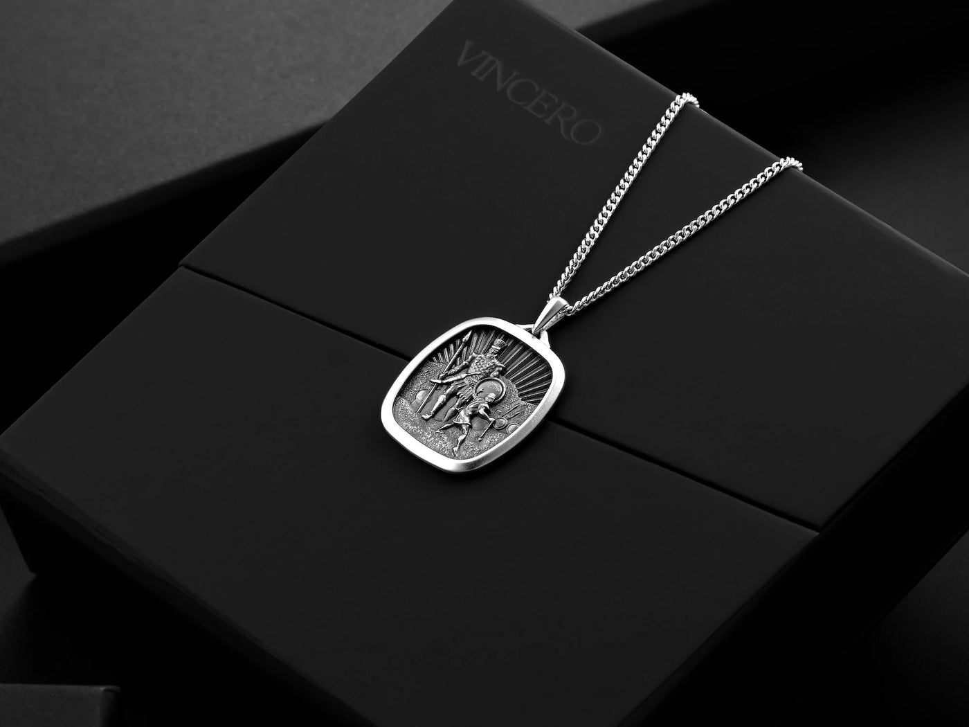 Silver necklace with a pendant on a black box labeled 'Vincero'.