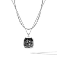 Silver necklace with a detailed pendant on a white background