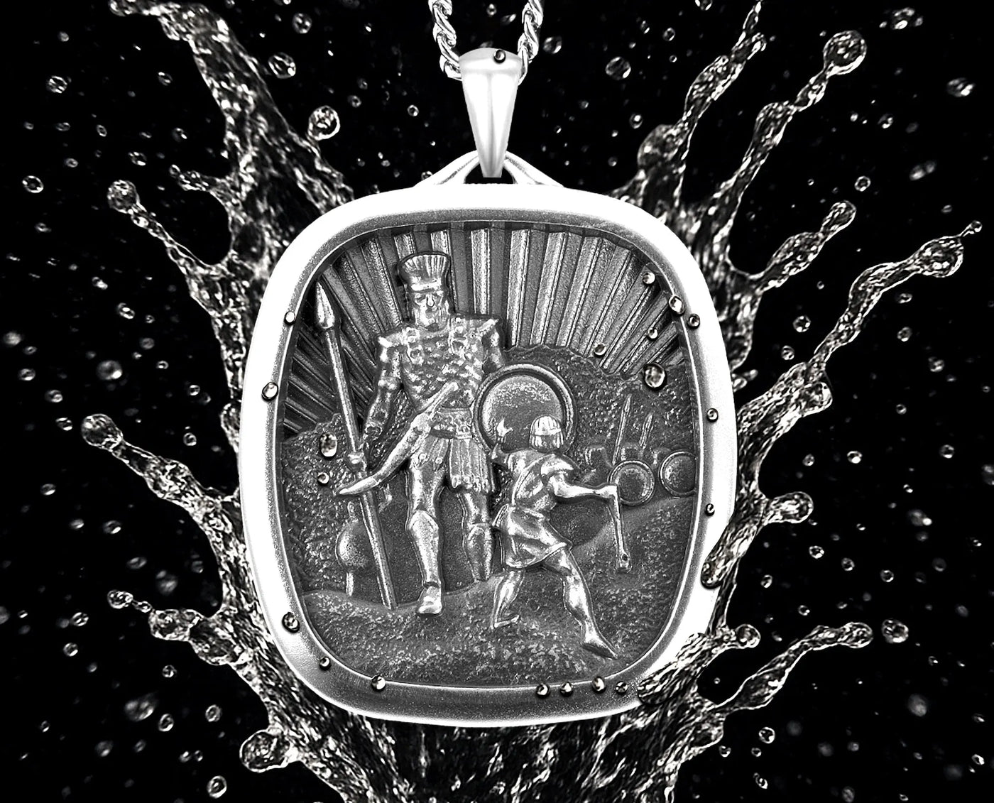 Silver pendant with engraved design of a warrior and shield, surrounded by water droplets.