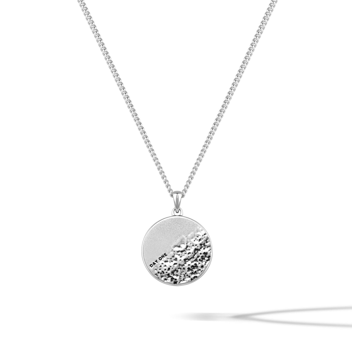 Silver necklace with a round pendant on a white background