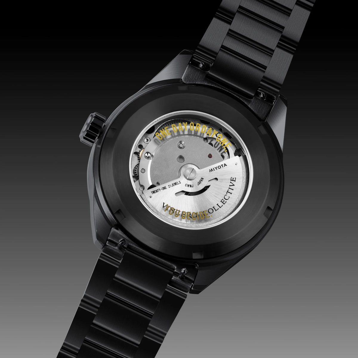 A black ceramic watch with a transparent back showing the Miyota automatic movement and gold-toned text, set against a dark gradient background.