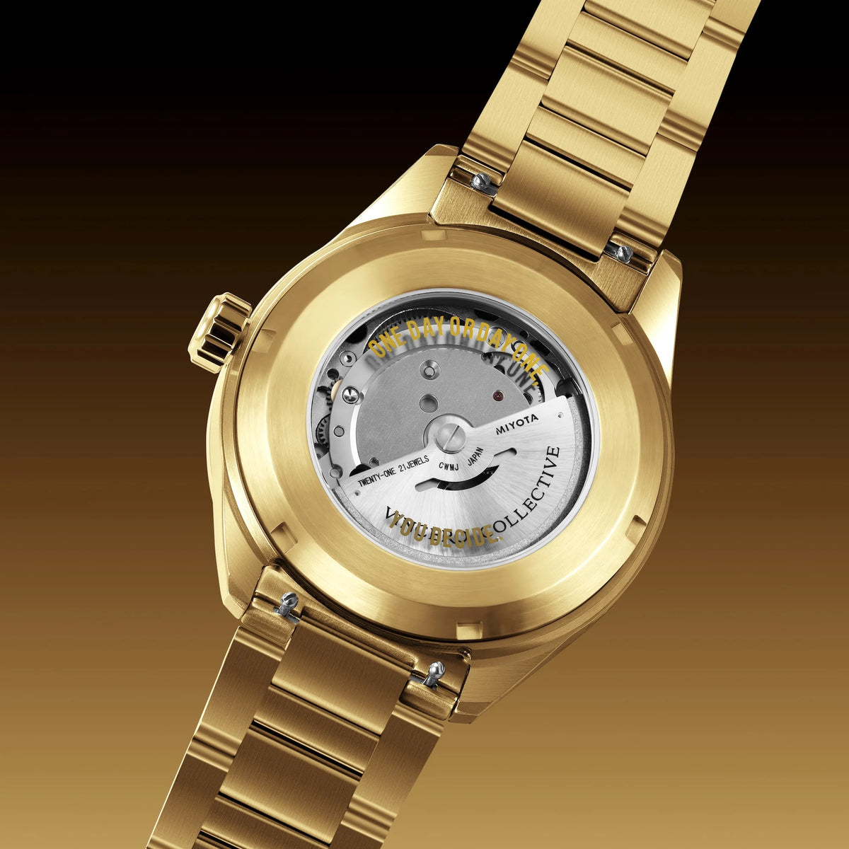 Gold-tone stainless steel automatic watch with a transparent back showing the mechanical movement, set against a dark brown gradient background.