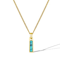 Gold necklace with a turquoise pendant on a white background