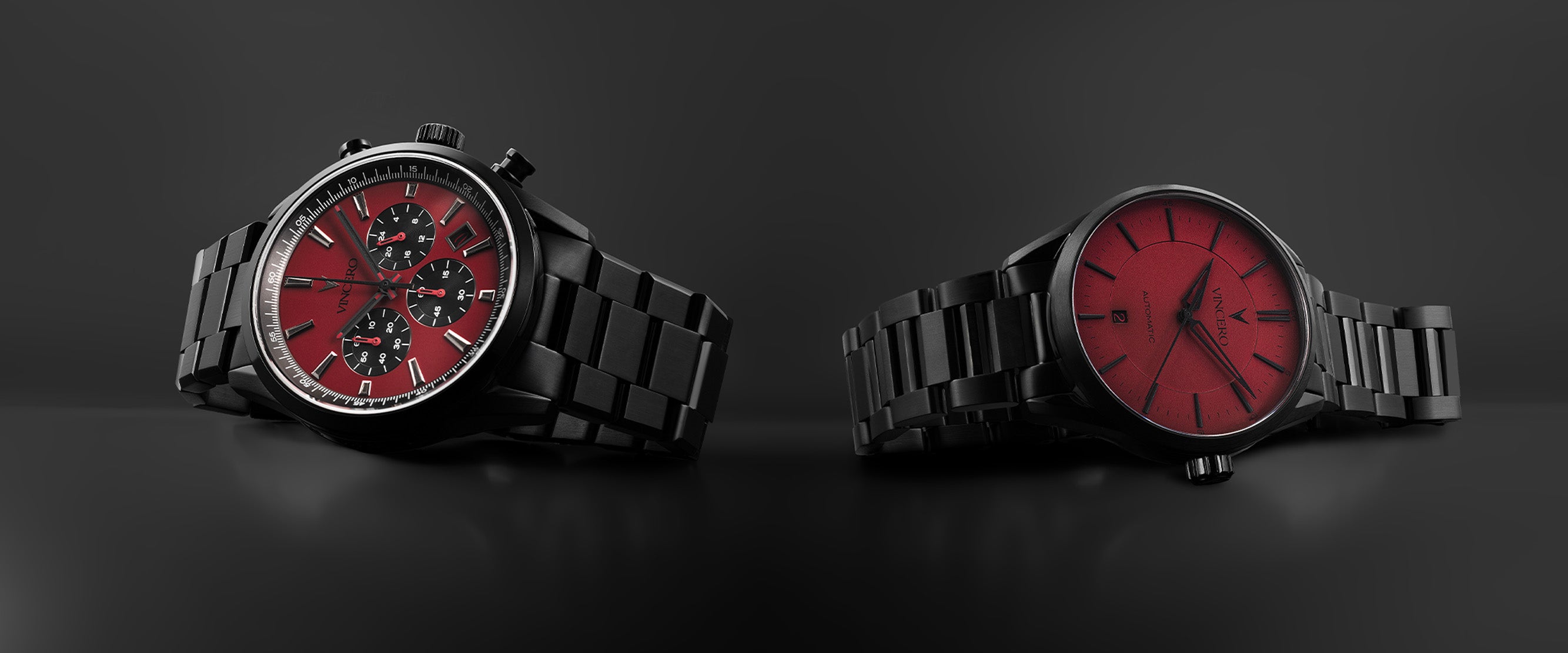 Two black watches with red faces on a dark background