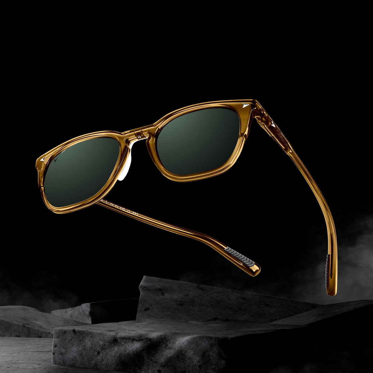Gold-framed sunglasses with dark lenses on a black background