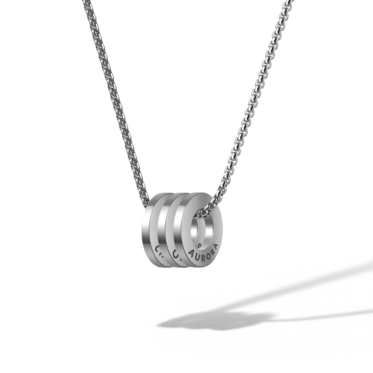 Silver necklace with three round pendants on a white background