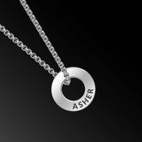 Silver necklace with a round pendant engraved with 'ASHER' on a black background