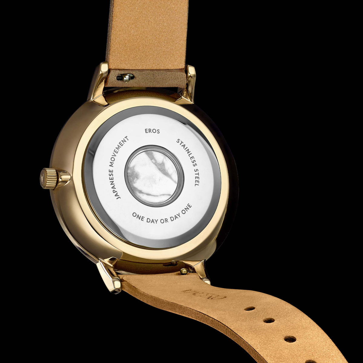 Watch with gold case, brown leather strap, and visible brand name on a black background