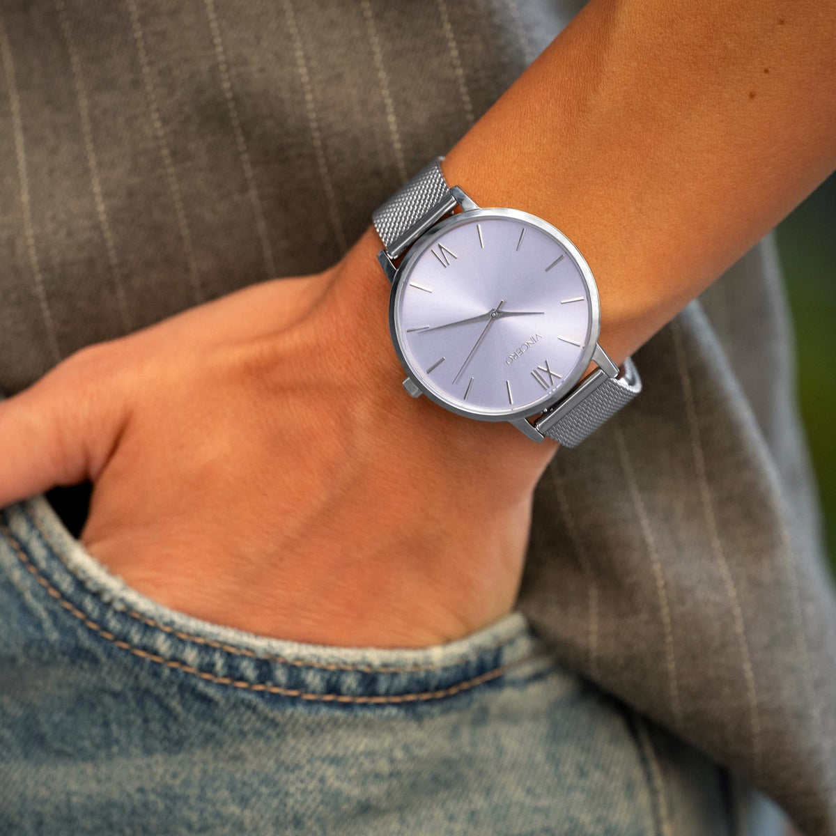 Silver watch on a wrist with a blurred background