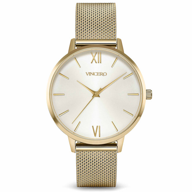 A gold-colored Vincero analog watch with a mesh band and a white dial.